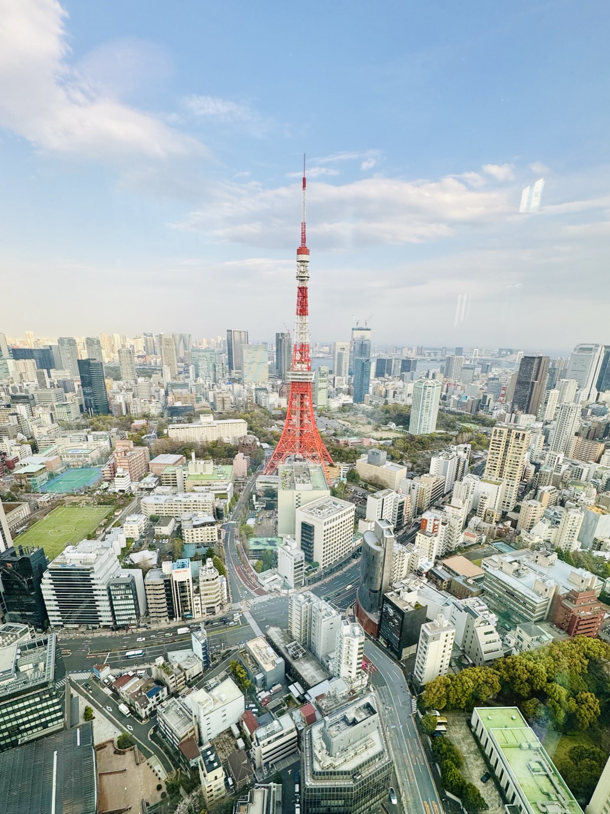 Aerial view looking down on Tokyo Tower with the city spread out under a blue sky