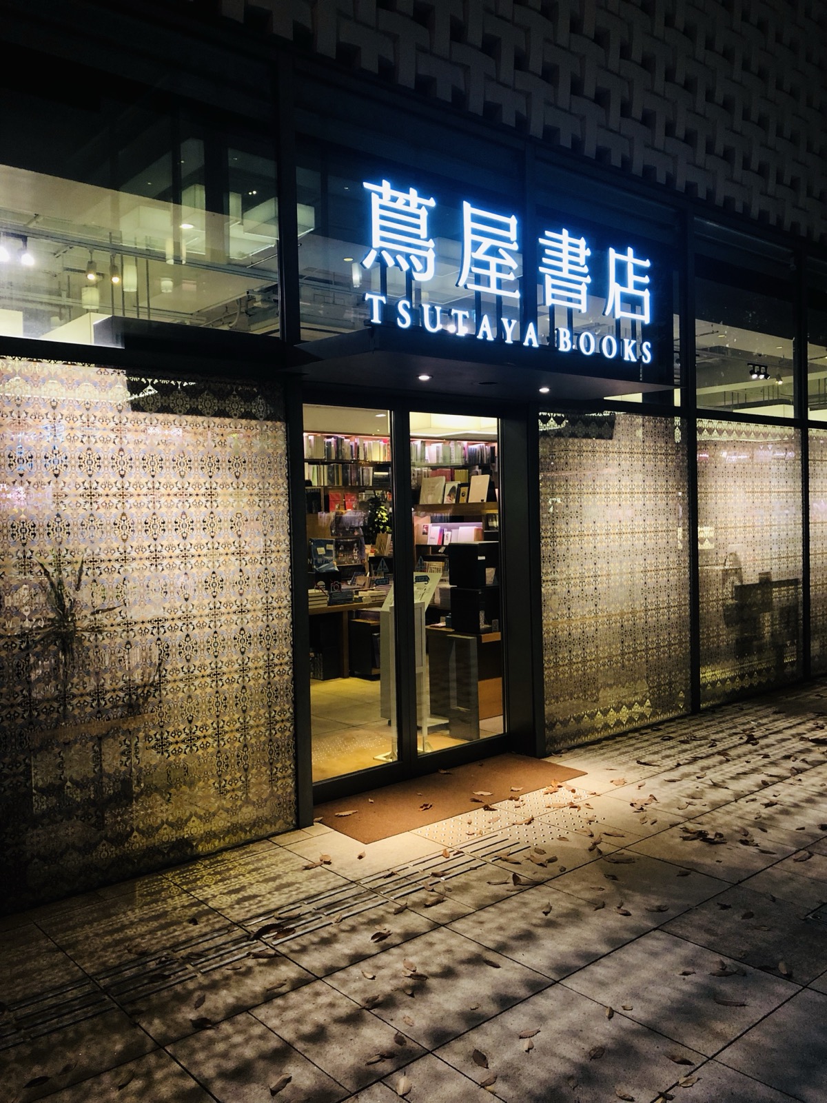 The lattice-patterned facade of Tsutaya Books lit up at night